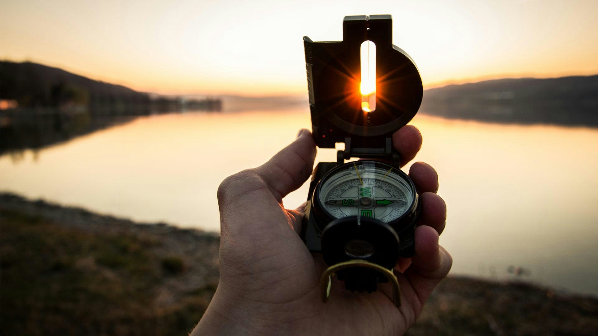 Person Holding Compass in Sunset